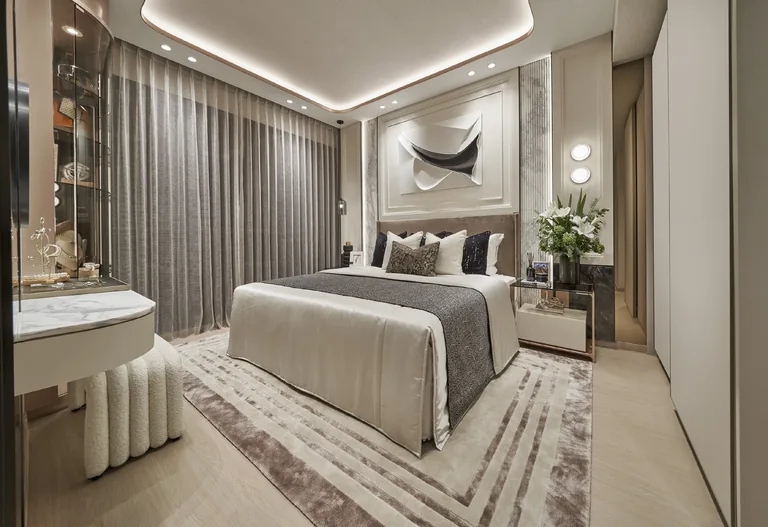 The Orie show-unit interior, for illustration only: a master bedroom with a padded headboard wall, a dressing table and full-length curtains